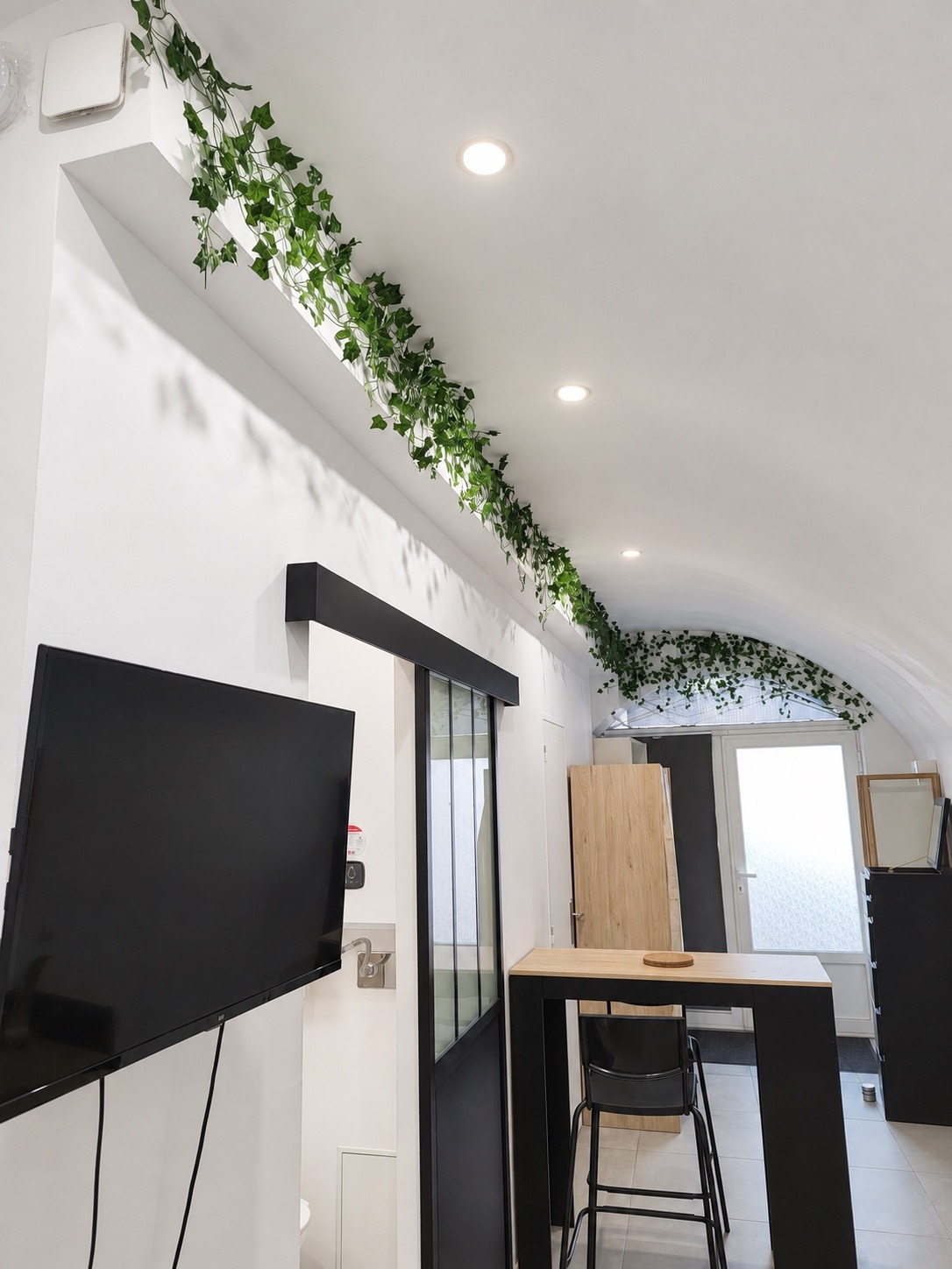 Plafond voûté et spots du studio, vue vers l’entrée