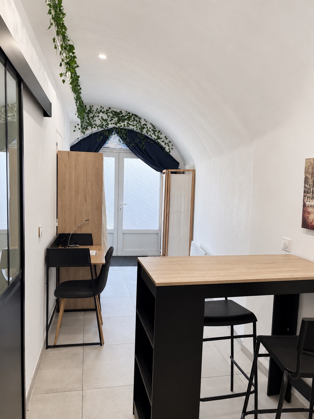 Espace repas lumineux du studio près de la porte-fenêtre